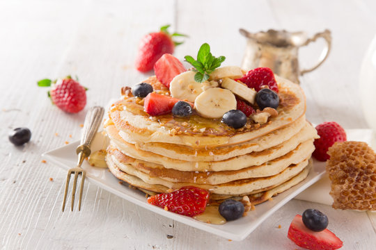 delicious pancakes on wooden table with fruits