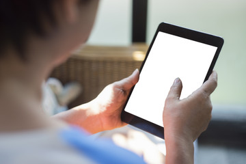 Close up of mature senior woman's hand holding tablet over blurred background at coffee cafe to read or play a tablet ,selective focus ,filtered image, white screen clipping path included
