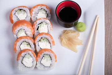 Philadelphia sushi roll with red fish on a white plate