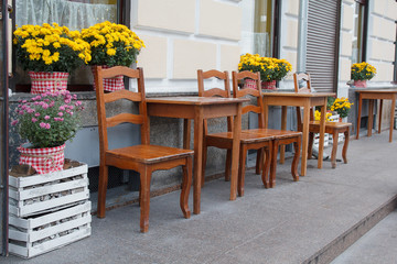 Beautiful flowers in wooden boxes near the cafe. City
