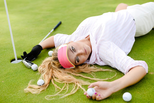 Portrait of beautiful woman relaxing during playing golf on a green field outdoors background