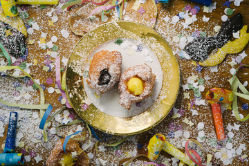 Carnivalesque composition. Top view of an elegant dish with italian fried carnival dessert called...