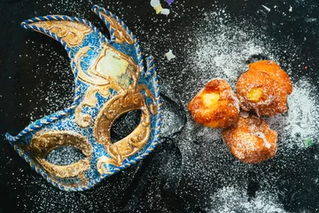 Rolgordijnen Carnivalesque composition. Top view of italian fried carnival dessert called "frittelle" or " bombs" with creme and chocolate icing sugar  © jon11