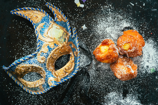 Carnivalesque composition. Top view of italian fried carnival dessert called "frittelle" or " bombs" with creme and chocolate icing sugar 