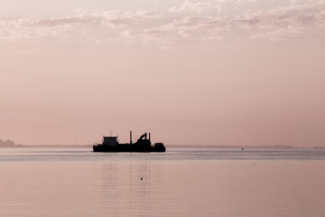 Cargo ship in the sea at dawn