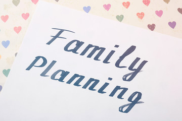 Sheet of paper with words FAMILY PLANNING, closeup