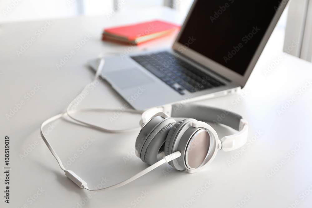 Wall mural Headphones and laptop on office table