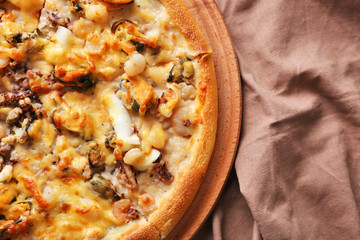 Delicious seafood pizza and napkin, close up