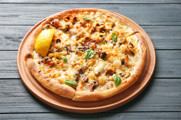 Delicious seafood pizza on grey wooden background