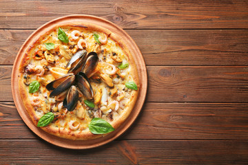 Delicious seafood pizza on wooden background