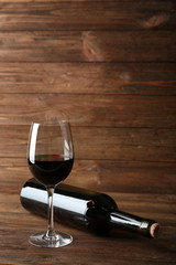 Wine bottle and glass on wooden background