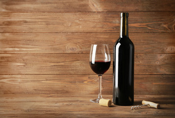 Wine bottle and glass on wooden background