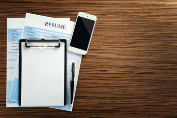 Employer workplace with clipboard and resumes