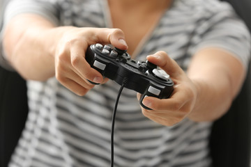 Teenager playing videogame at home, closeup