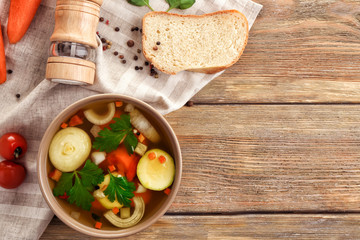 Bowl with vegetable soup on wooden table