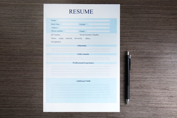 Resume and pen on wooden table