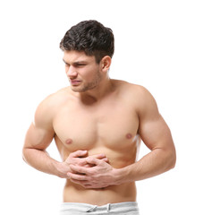 Handsome young man suffering from abdominal pain on white background