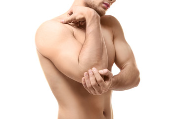 Young man suffering from pain in elbow on white background, closeup