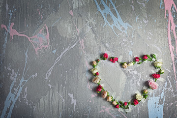 Heart made of fresh flowers on grey textured background