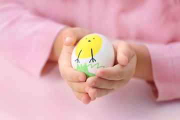 Little girl holding decorating Easter egg