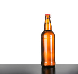 Bottle of beer on table against white background