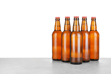 Bottles of beer on table against white background