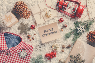 Fototapeta na wymiar Christmas decorations and wish card on soft fabric background