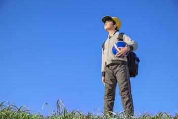 サッカーボールを持ち遠くを見つめる小学生の男の子