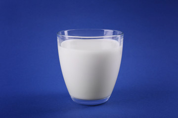 Glass of milk on blue background