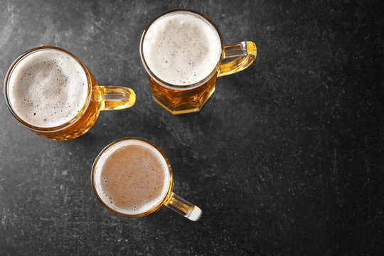 Mugs with beer on table