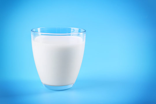 Glass of milk on blue background