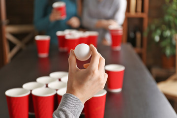 Woman holding ball for Beer Pong game