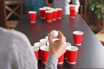 Woman holding ball for Beer Pong game