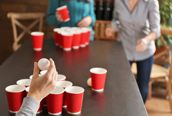 Woman holding ball for Beer Pong game