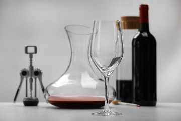 Glass and decanter on table against light background