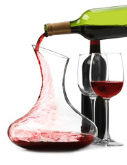 Pouring wine in carafe on white background