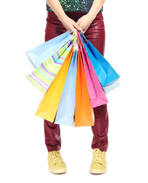 Woman's legs and shopping bags on light background