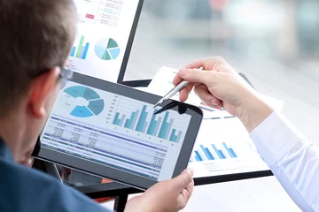 Foto op Plexiglas Business colleagues working and analyzing financial figures on a digital tablet © Saklakova