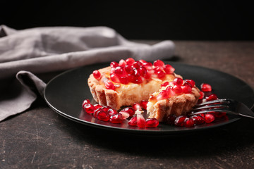 Tasty tart with fresh seeds of pomegranates served on plate