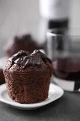 Delicious chocolate muffin on grey table, close up