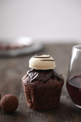 Closeup of delicious chocolate cake with truffles and red wine on wooden table