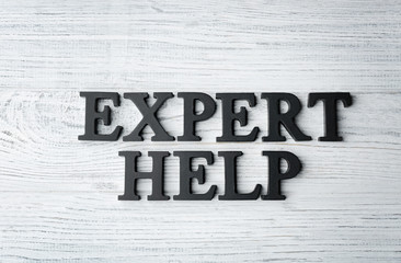 Naklejka premium Phrase EXPERT HELP on wooden background