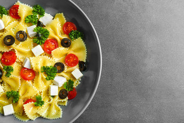 Pasta salad with tomatoes and cheese on table