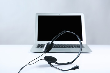 Laptop with headset on white table