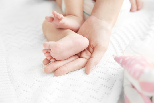 Little baby feet in mother's hands