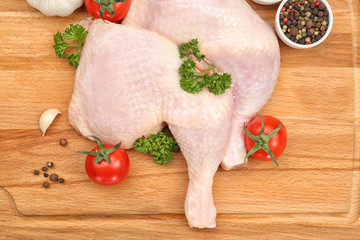Wooden board with raw chicken thighs