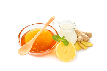 Natural medicine concept. Honey, lemon, milk and ginger on white background