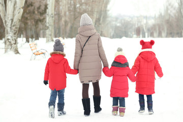Young woman with children walking on snow
