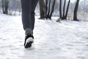 Sportive young woman running in winter park