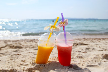 Travel to island Koh Larn, Thailand. Two glasses with mango juice and watermelon juice on the beach in the sunny summer weather.